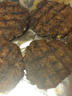 A picture of Juicy venison burgers in a skillet.