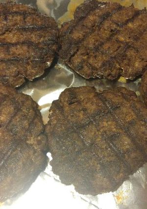 A picture of Juicy venison burgers in a skillet.