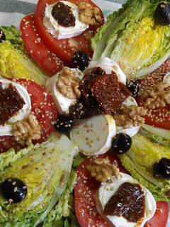 Una foto de Cogollos con tomates secados al sol y queso de cabra con sésamo tostado