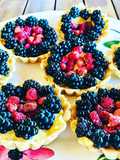 Piccoli gusci di friabile frolla, guarniti con vellutata crema pasticcera e frutti di bosco