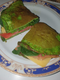 Una foto de Tortilla de espinaca baby, salmón, queso, tomate y aguacate