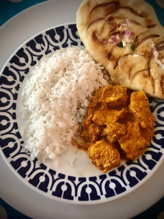 Una foto de Pollo tikka malasa con pan naan y arroz largo