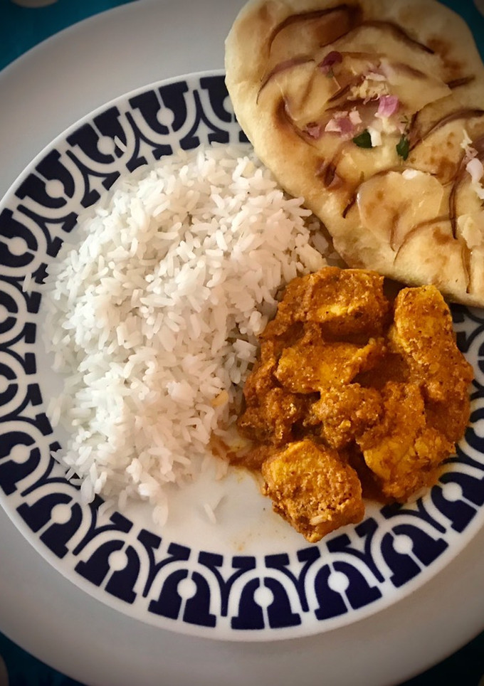Una foto de Pollo tikka malasa con pan naan y arroz largo