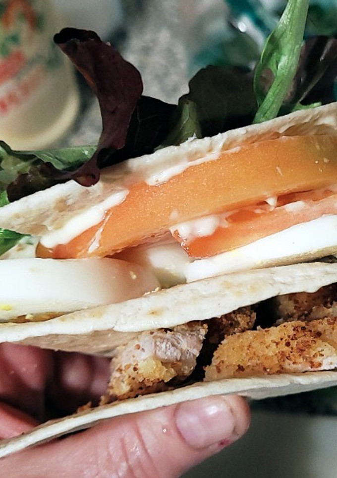Una foto de Wrap Hack con lomo rebozado, tomate, lechuga y huevo duro