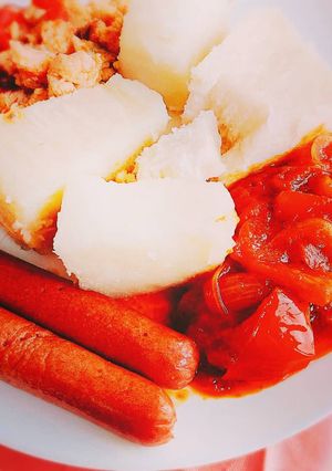 A picture of Boiled yam,pepper sauce and sausages.