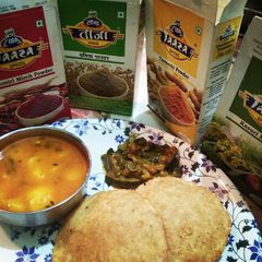 A picture of Poori aalu & khatti meethi kaddu sabzi.