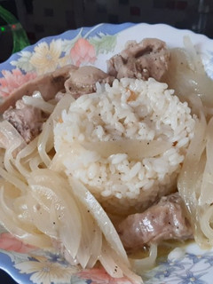 Una foto de Conejo encebollado con arroz blanco al ajillo