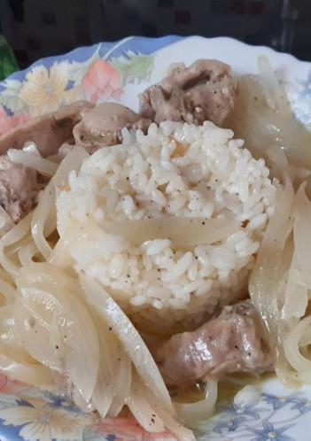 Una foto de Conejo encebollado con arroz blanco al ajillo