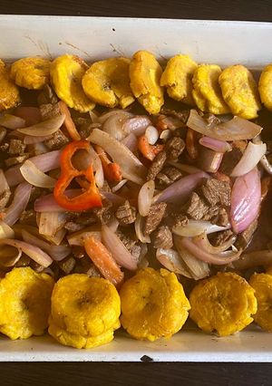 Una foto de Lomito saltado acompañado de patacones