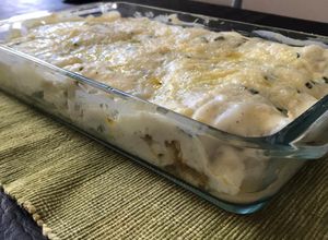 Una foto de Niños envueltos en repollo de carne con salsa blanca al horno
