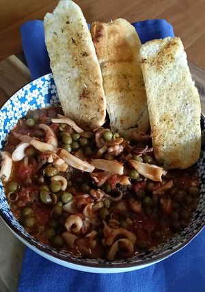 Foto di Calamari in umido con piselli e bruschette di pane
