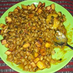 A picture of Beans porridge with fish and fried plantains.