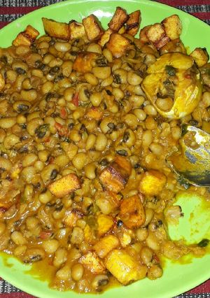 A picture of Beans porridge with fish and fried plantains.