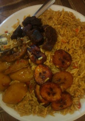 A picture of Jallof rice with plaintains and Irish.