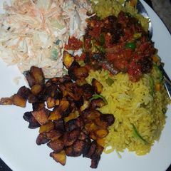 A picture of Fried rice with sauce and coslow.