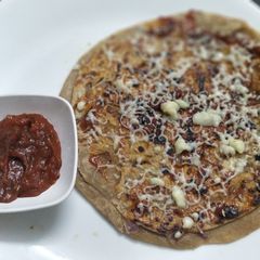A picture of Onion pizza paratha with pizza sauce.