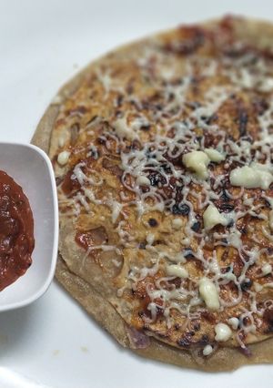 A picture of Onion pizza paratha with pizza sauce.