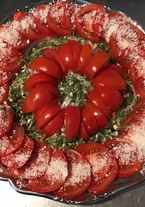 Une photo de Salade de tomates à l oignon doux d Italie,herbes aromatiques et parmesan