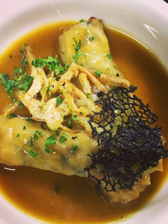 Una foto de Canelón de pasta wonton rellena de gambas y shiitake con fondo del jugo de la gamba