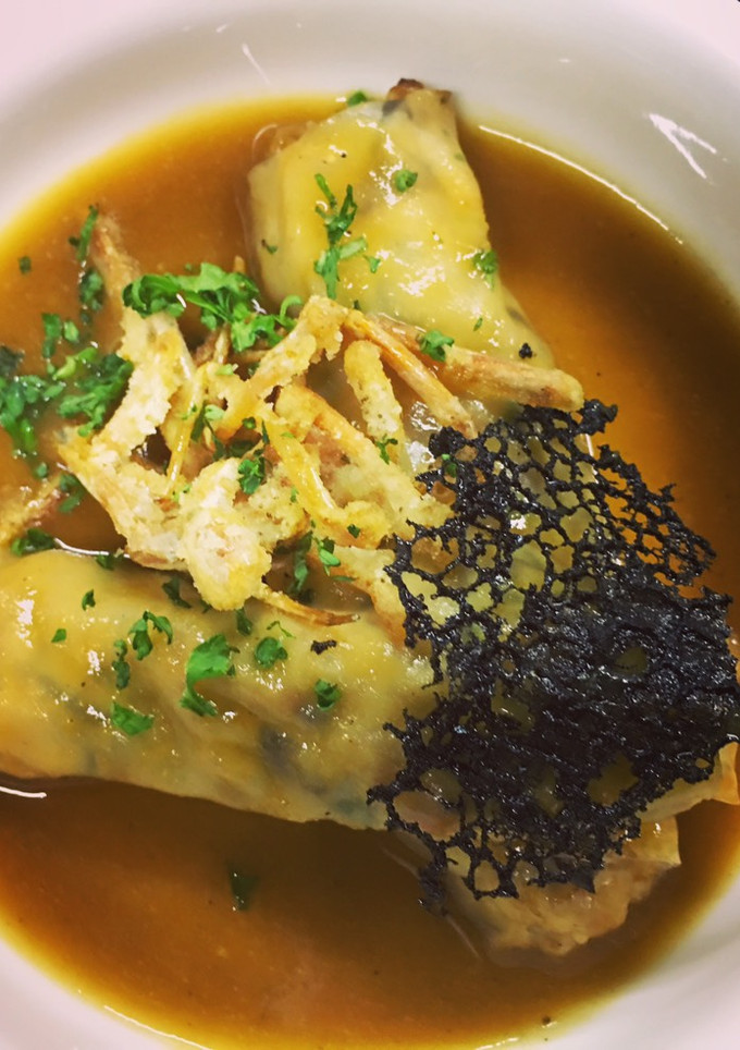 Una foto de Canelón de pasta wonton rellena de gambas y shiitake con fondo del jugo de la gamba