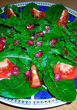 Foto principal de Ensalada de espinaca, diente de león, granada y tomates