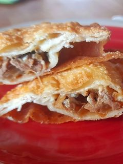 Una foto de Empanada de mechada, cebolla caramelizada y queso azul