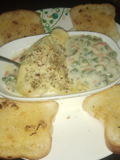 A picture of Potato baked dish with garlic bread.