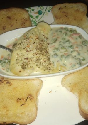 A picture of Potato baked dish with garlic bread.