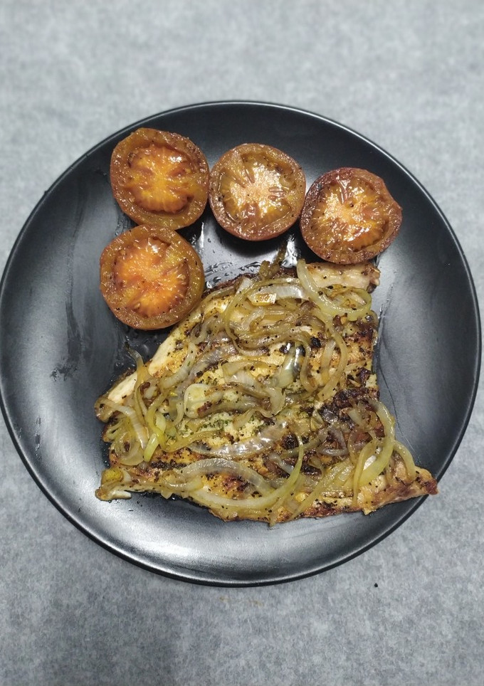 Una foto de Lubina a la espalda encebollada y tomates a la plancha