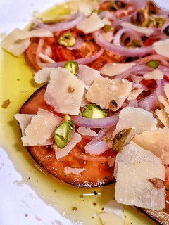 Una foto de Carpaccio de tomate con cebolla morada encurtida