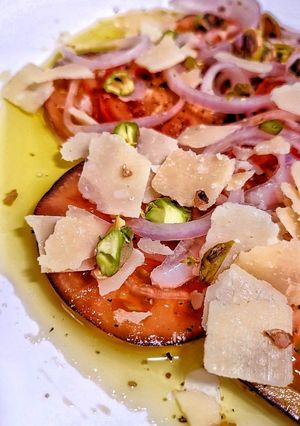 Una foto de Carpaccio de tomate con cebolla morada encurtida