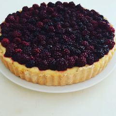A picture of Baked cheesecake tart with blackberries.