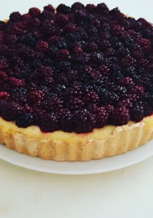 A picture of Baked cheesecake tart with blackberries.