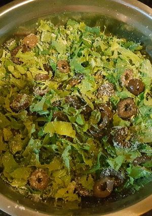 Una foto de Ensalada de rúcula, queso rallado y aceitunas negras