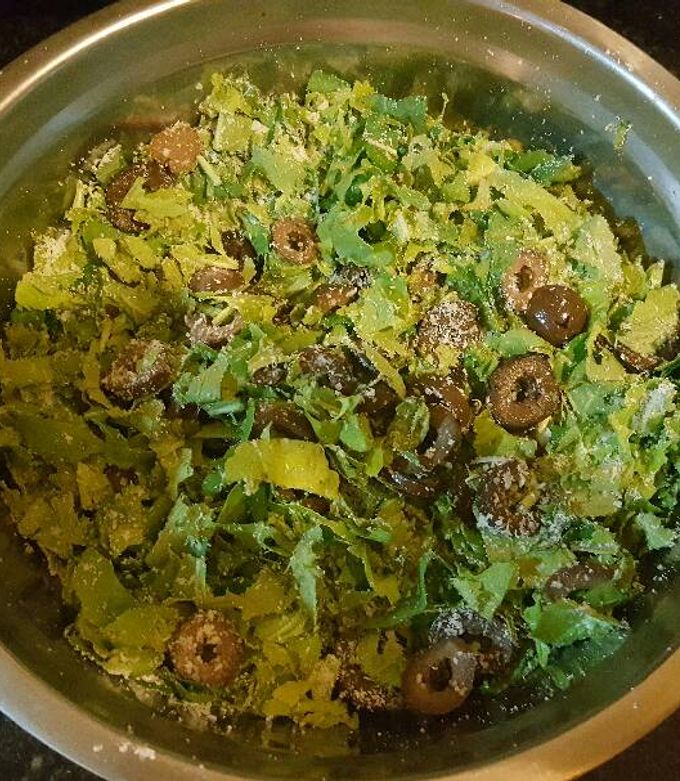 Una foto de Ensalada de rúcula, queso rallado y aceitunas negras