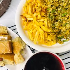 A picture of Chips with scrambled egg served with hot tea.