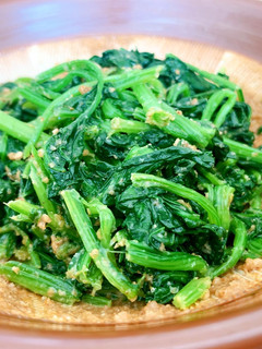 A picture of Cooked spinach seasoned with sweet sesame sauce.