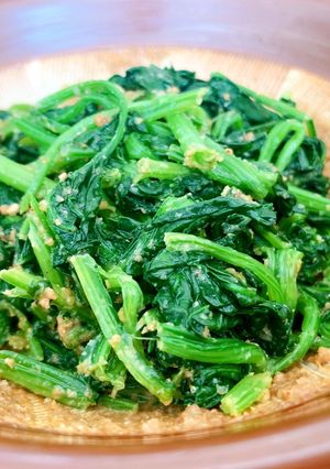 A picture of Cooked spinach seasoned with sweet sesame sauce.