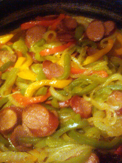 A picture of sausages and peppers.