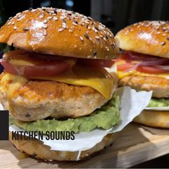 A picture of Salmon burgers 🥬🥑🐟🧀🍅.