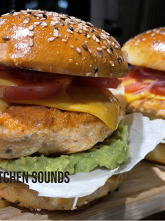 A picture of Salmon burgers 🥬🥑🐟🧀🍅.