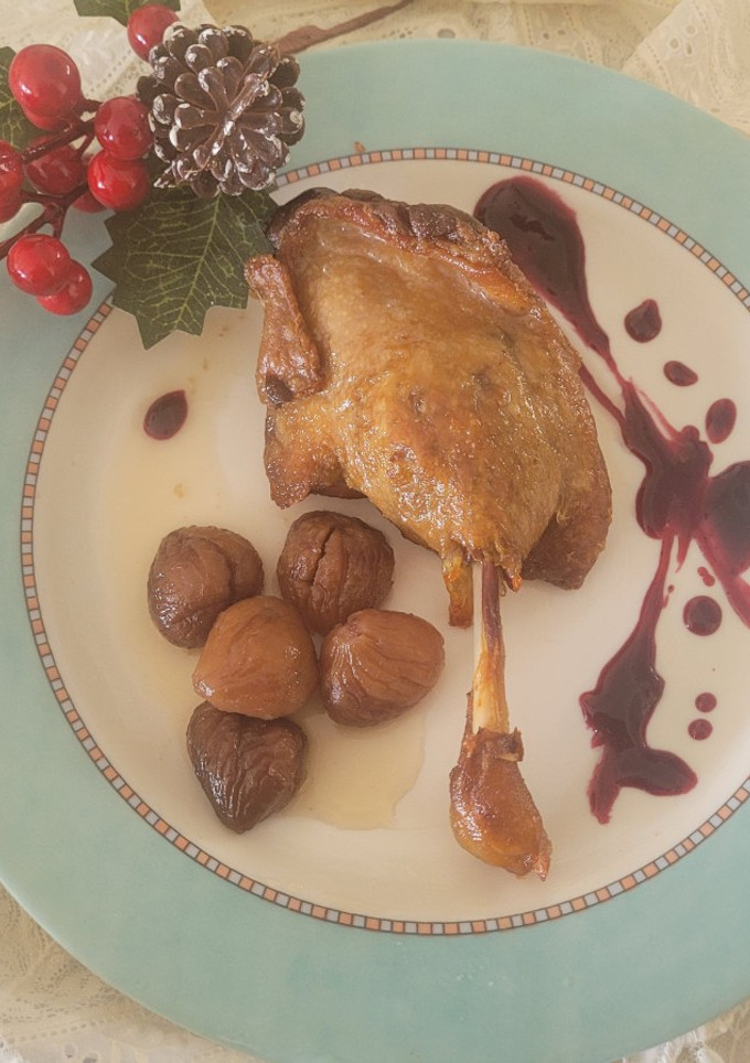 Una foto de Confit de Canard con salsa de arándanos y castañas en almíbar en un plis plas