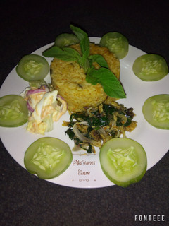 A picture of Jollof rice with dried fish sauce and coleslaw.