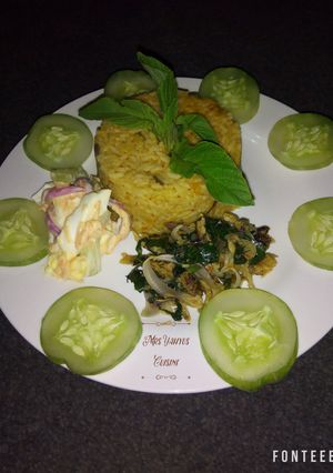 A picture of Jollof rice with dried fish sauce and coleslaw.