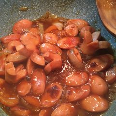 A picture of Sweet and Sour sausage with onion.