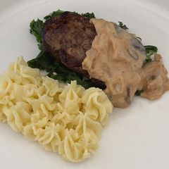 A picture of Filet Mignon With Creamy Mashed Potato And kale, Served With A Peppercorn Sauce.