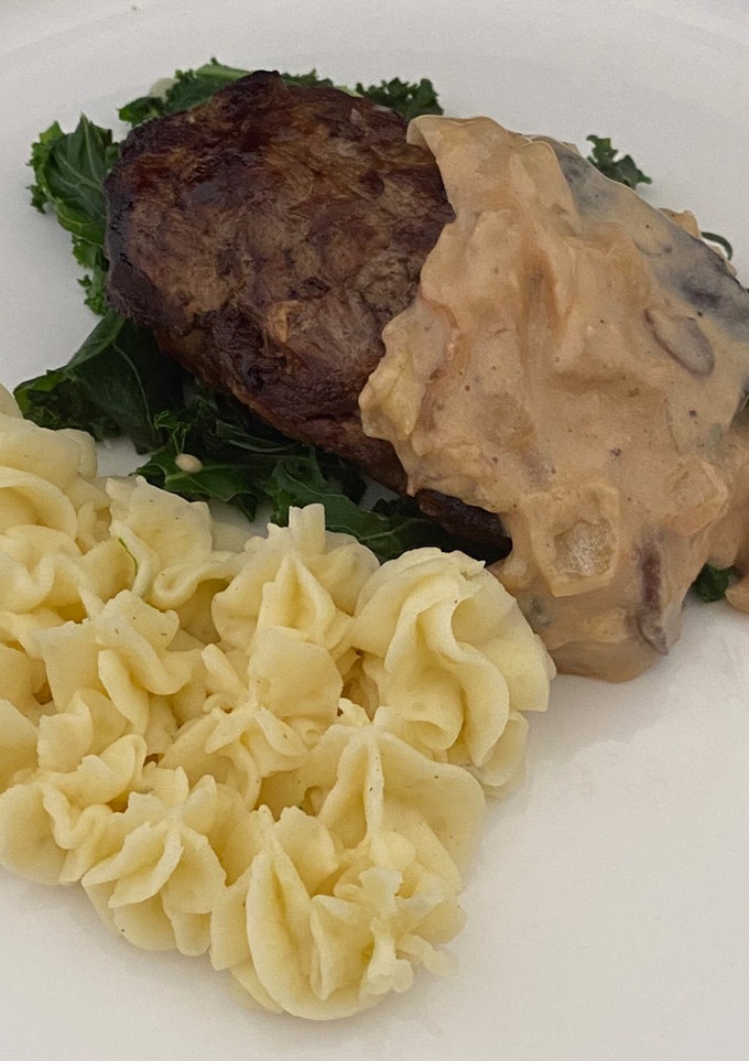 A picture of Filet Mignon With Creamy Mashed Potato And kale, Served With A Peppercorn Sauce.