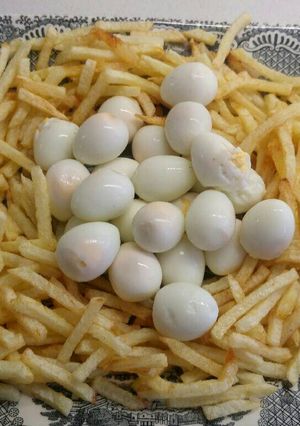Una foto de Nido de huevitos de codorniz y patatas paja