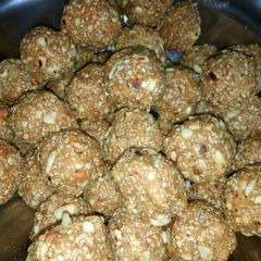 A picture of Til ladoos with coconut and nuts.