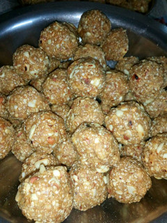A picture of Til ladoos with coconut and nuts.